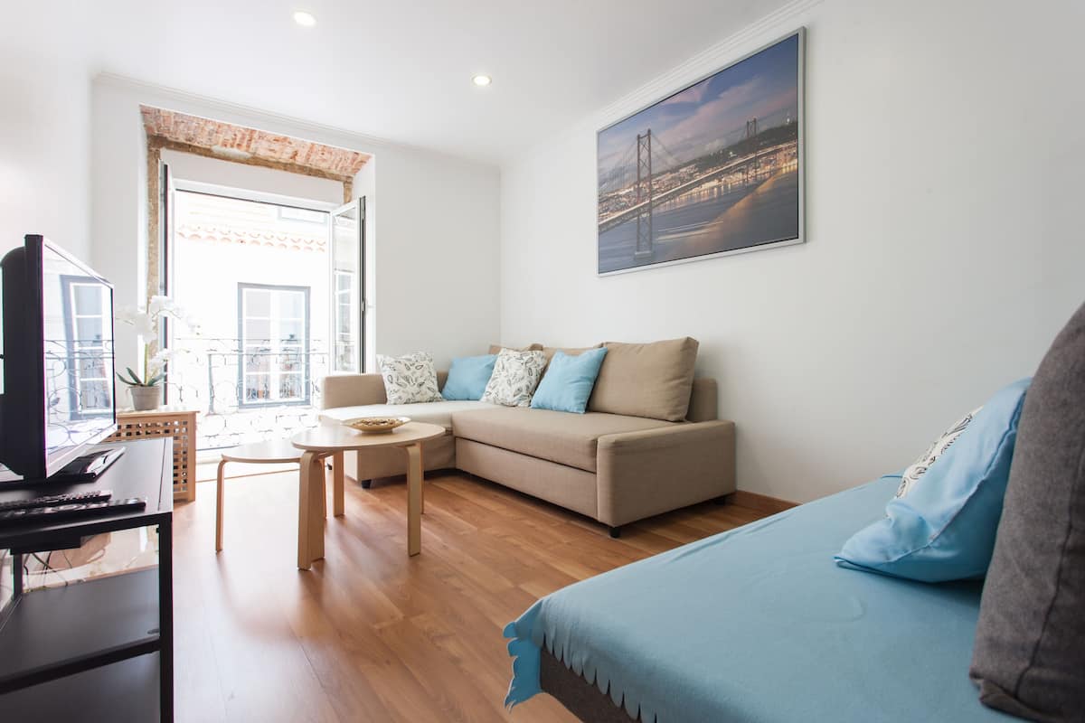 Appartement, 1 slaapkamer (1E) | Woonkamer | Een 32-inch flatscreentelevisie met kabelzenders en televisie