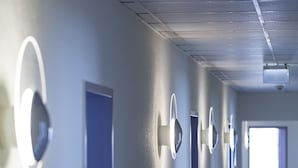 A hotel hallway with doors, light fixtures, and a ceiling projector. - BIG Reisehotel Wolfen (Bitterfeld-Wolfen)