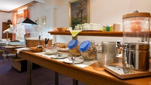 A breakfast buffet with various food items, a coffee machine, and a painting on the wall. - BIG Reisehotel Wolfen (Bitterfeld-Wolfen)