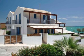 Enjoy ocean views from the spacious balcony with a pergola, and relax in the covered outdoor area surrounded by a well-maintained garden.