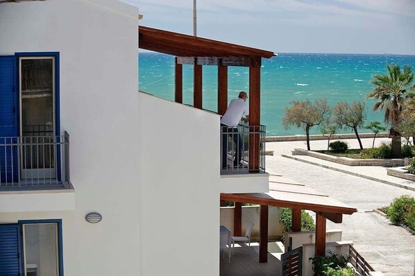 Enjoy a balcony with a pergola and seating area overlooking the water.