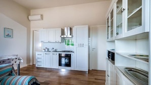 Apartamento, 2 habitaciones, vistas al mar, frente a la playa | Cocina privada | Frigorífico grande, horno, placa de cocina y utensilios de cocina