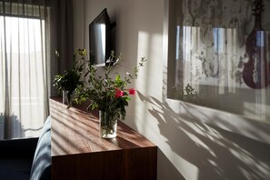 A wooden table with a vase of flowers and a mirror on a wall. - B&B I Bannisti (Santeramo in Colle)