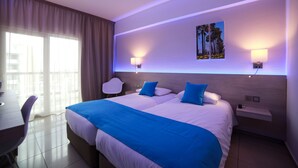 Une chambre d’hôtel moderne avec un grand lit, deux tables de chevet, un bureau et une chaise.