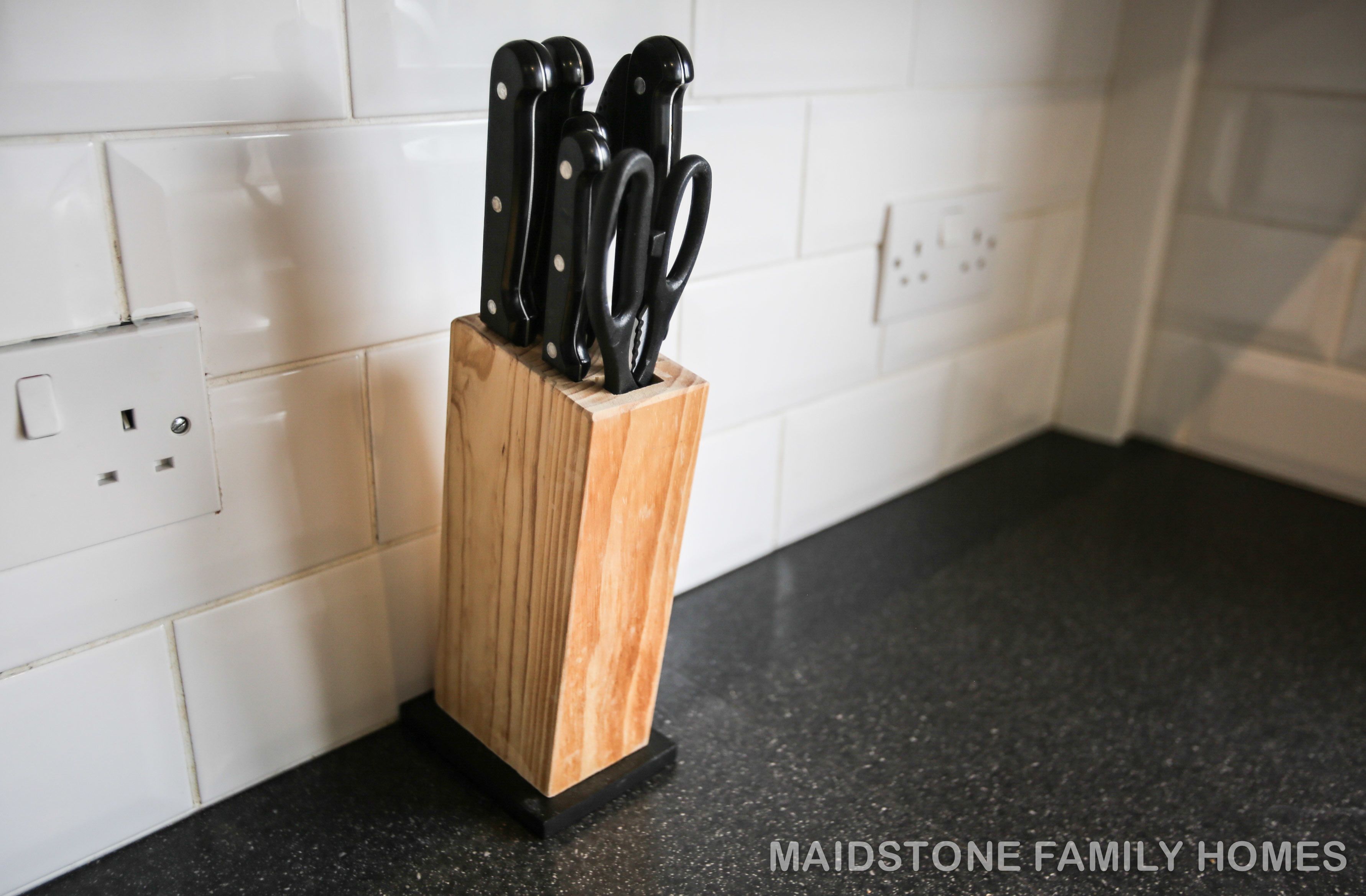 A kitchen counter with a knife block.