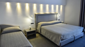 Ein Hotelzimmer mit zwei Betten, einem Nachttisch und einer Wandleuchte.