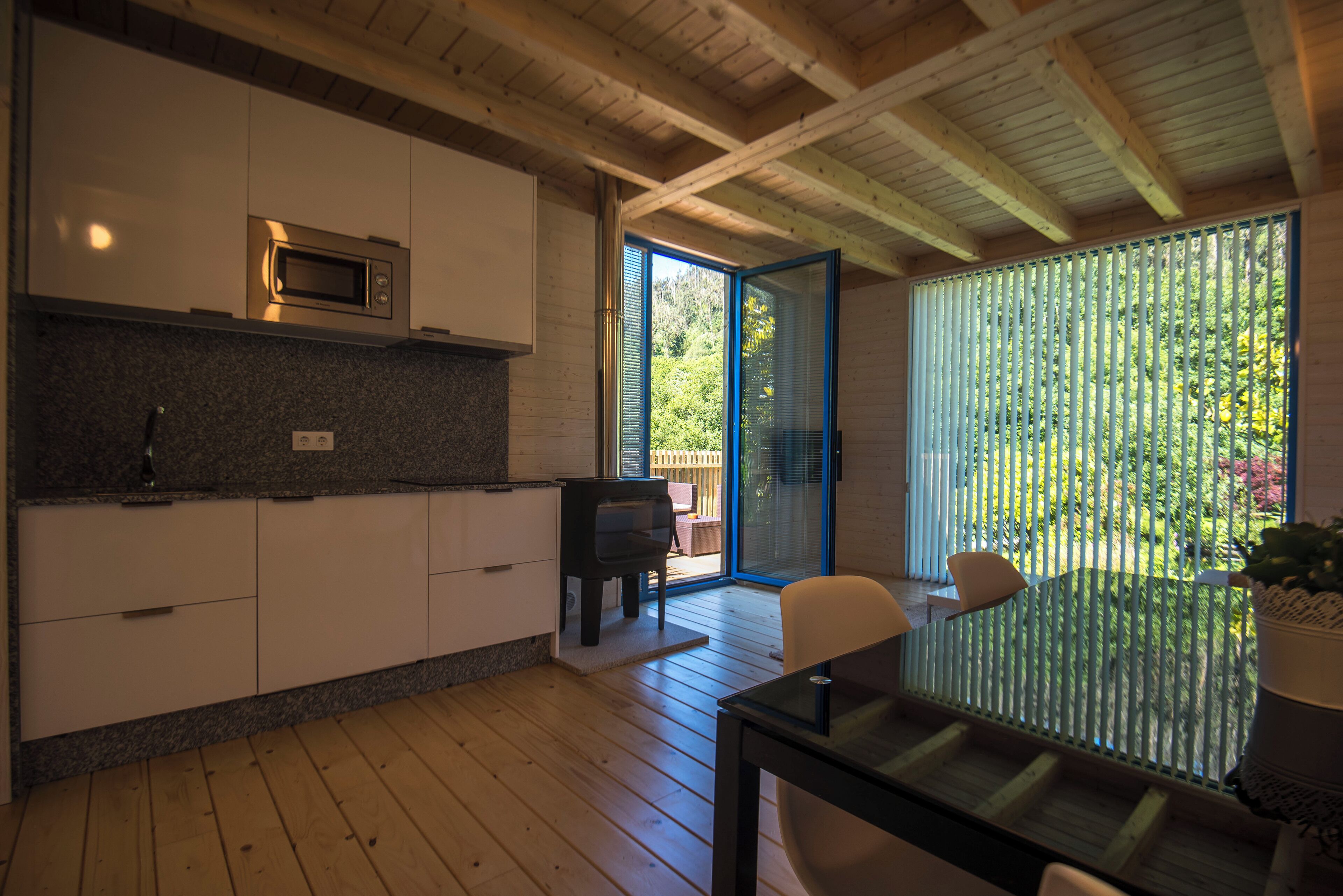 Une cuisine moderne équipée d’un four à micro-ondes, de meubles en bois et d’un coin repas avec une table et des chaises.