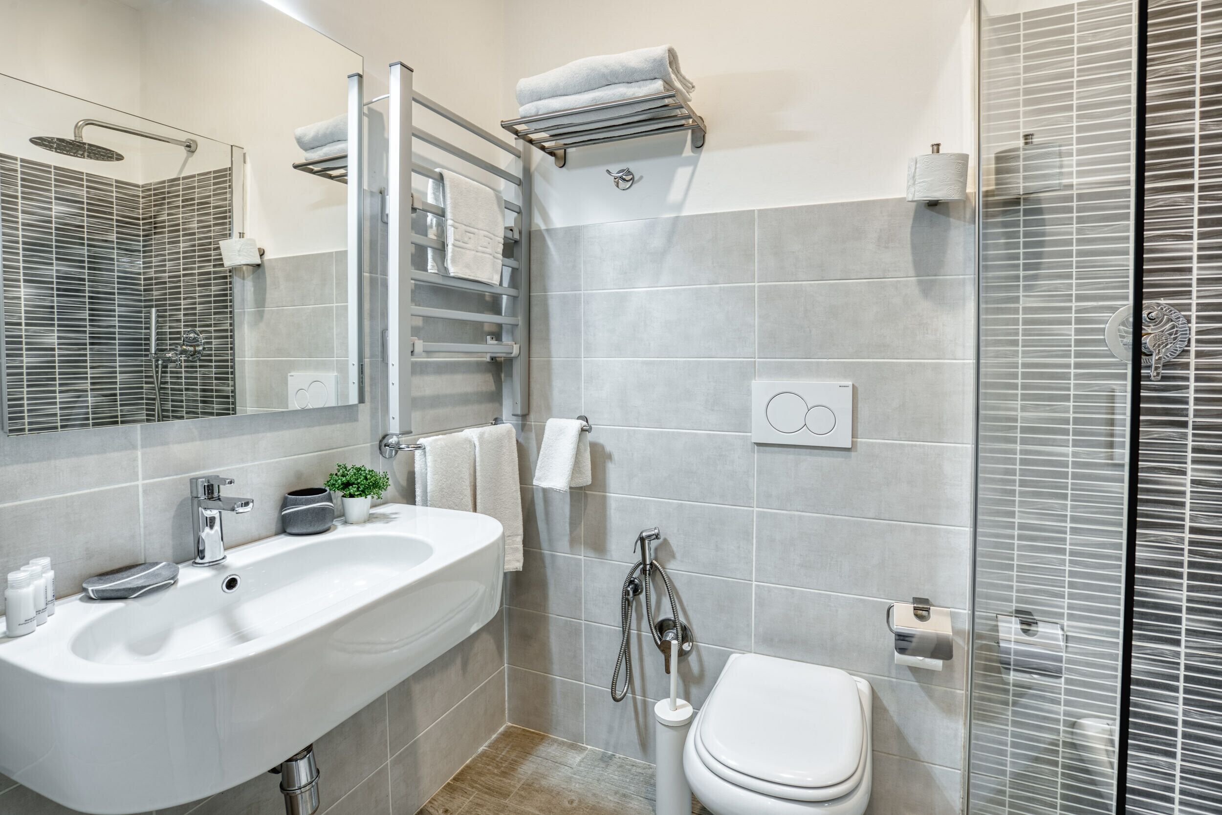 A modern bathroom with a large sink, toilet, and shower area.