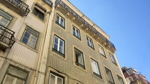 A multi-story building with a patterned facade, multiple balconies, and large windows. - The Color Hostel (Lisbon)