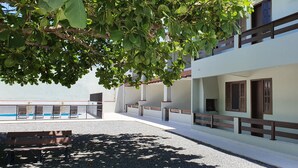 Un immeuble résidentiel doté d’un balcon, d’une piscine et d’une pancarte indiquant qu’un bien est à vendre.