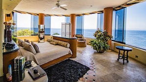 A spacious bedroom with a large bed, a desk, and a view of the ocean. - Luxurious Oceanfront Estate on Vallarta's South Shore, Pool, Jacuzzi, Chef, Maid (Puerto Vallarta)