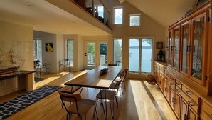 A spacious kitchen with a long wooden table, modern chairs, and a large wooden cabinet. - Hot Tub, Fireplace & Pet Friendly! Come Visit "Lake It or Knot"! (Huddleston)
