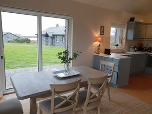 A kitchen with a dining area, a view of the outside, and a lamp on the counter.