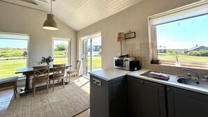 Una cocina con comedor, vistas al exterior y una ventana con vista al campo.