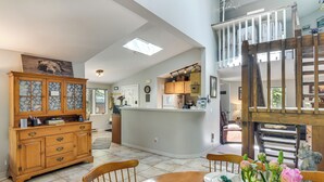 A spacious kitchen with a central island, wooden cabinets, and a dining area with a table and chairs. - Cabin on Clear Creek: A Hobbit’s Retreat! (Black Hawk)