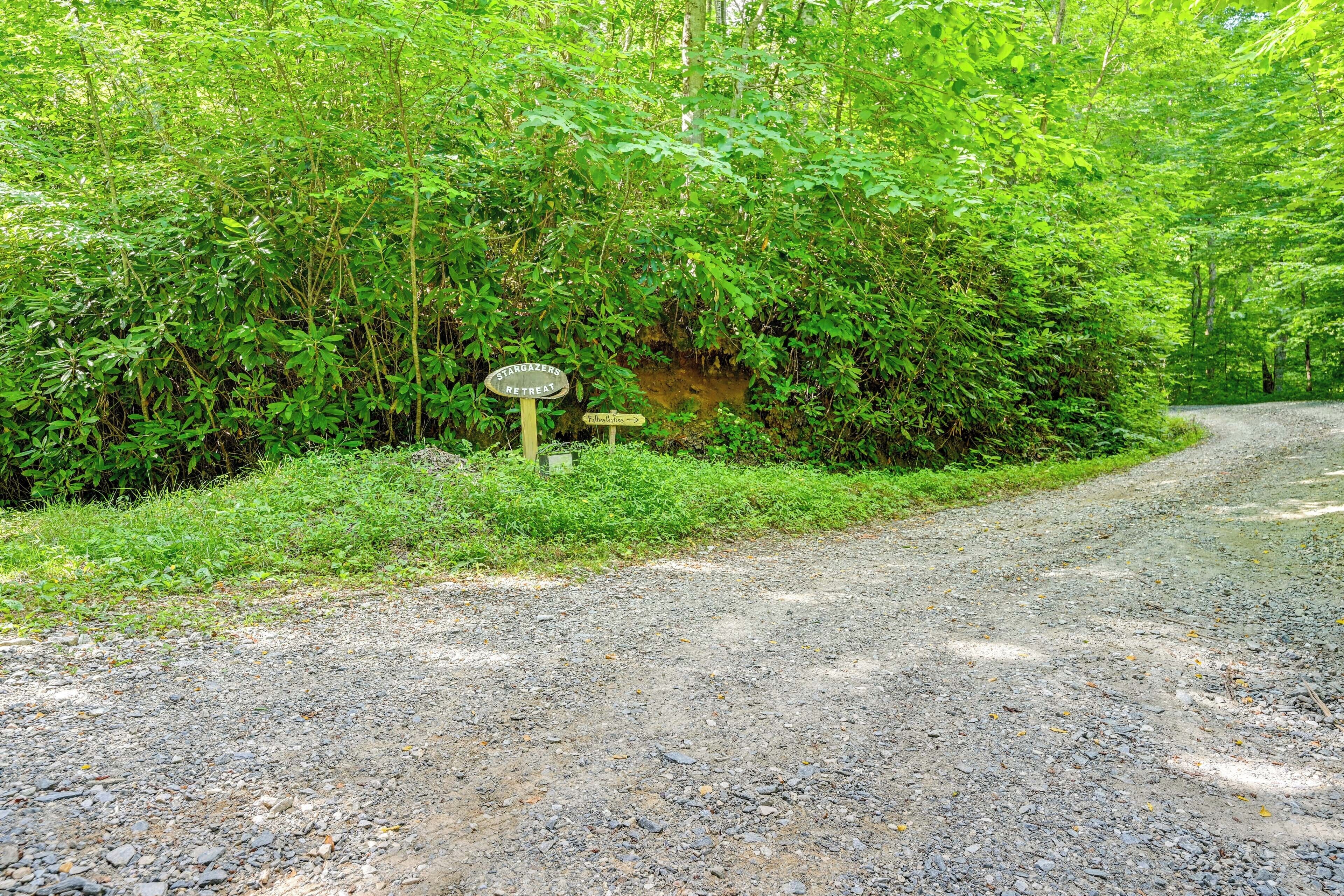 A gravel path leading through a forested area with a sign indicating a Stargazers Retreat.
