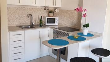 Een koffiezetapparaat/waterkoker, kookgerei, borden en bestek