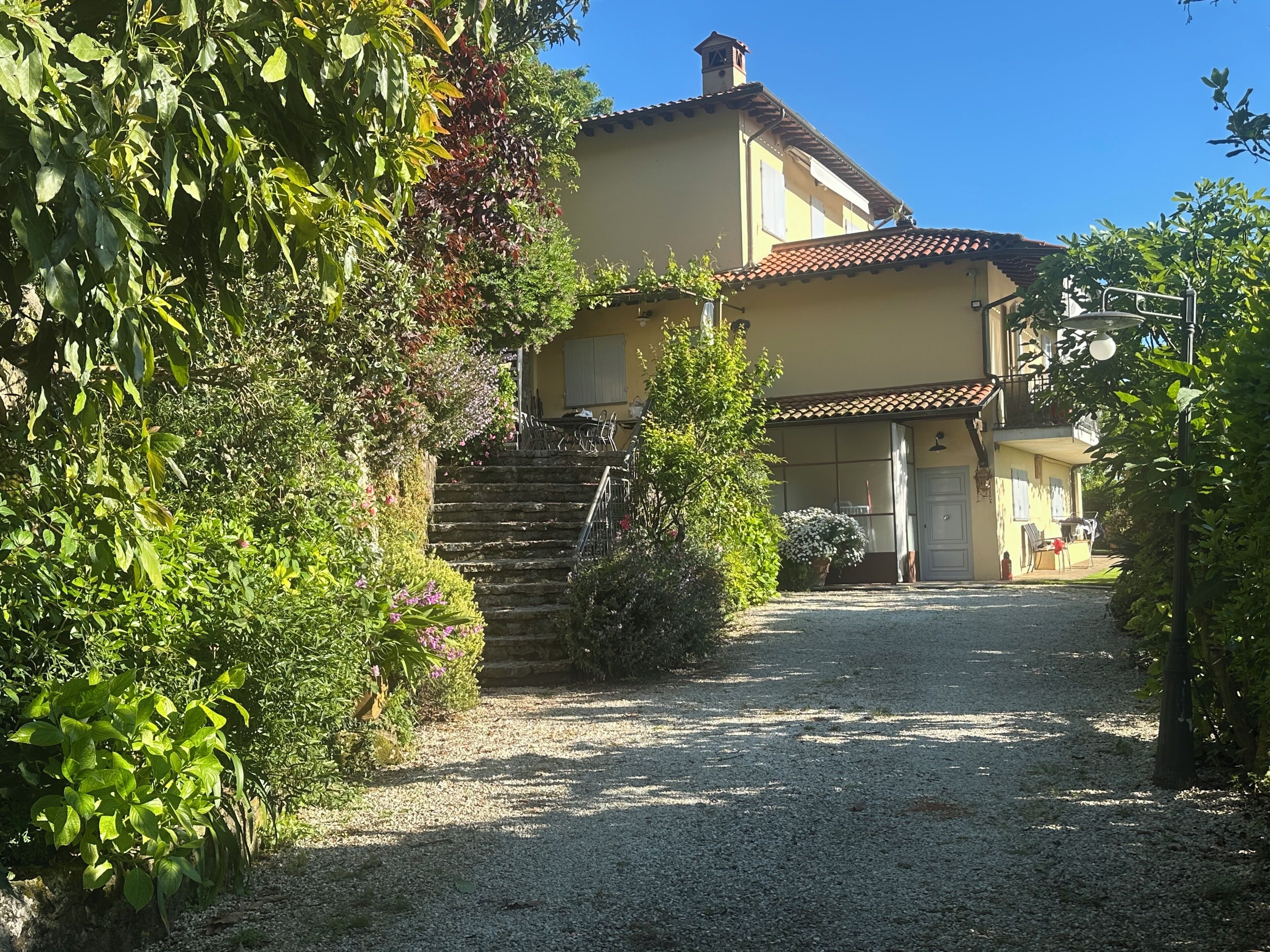 A two-story building with a gravel driveway leading to a wooden staircase.
