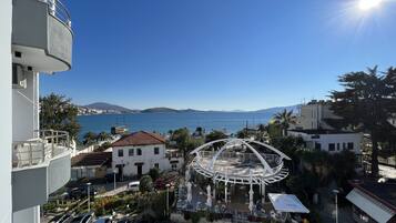 Un hotel frente al mar, con aparcamiento y un patio central con mobiliario exterior.