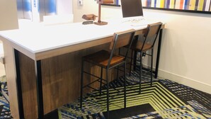 A small office area with a desk, two chairs, a computer, and a colorful striped wall. - Holiday Inn Express & Suites Elko by IHG (Elko)