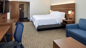 A hotel room with a bed, a desk, a chair, a TV, and a nightstand with a lamp. - Holiday Inn Express & Suites Elko by IHG (Elko)