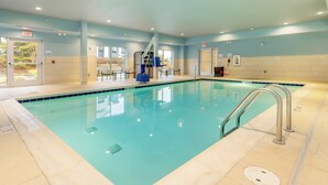 An indoor swimming pool with clear water, a lifeguard chair, and exit signs. - Holiday Inn Express & Suites Medford by IHG (Medford)