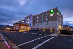 A Holiday Inn Express & Suites building with a covered entrance, multiple floors, and a parking lot. - Holiday Inn Express & Suites Medford by IHG (Medford)