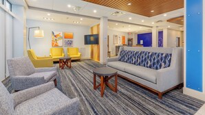 A modern lobby with seating, a television, and artwork on the walls. - Holiday Inn Express & Suites Medford by IHG (Medford)