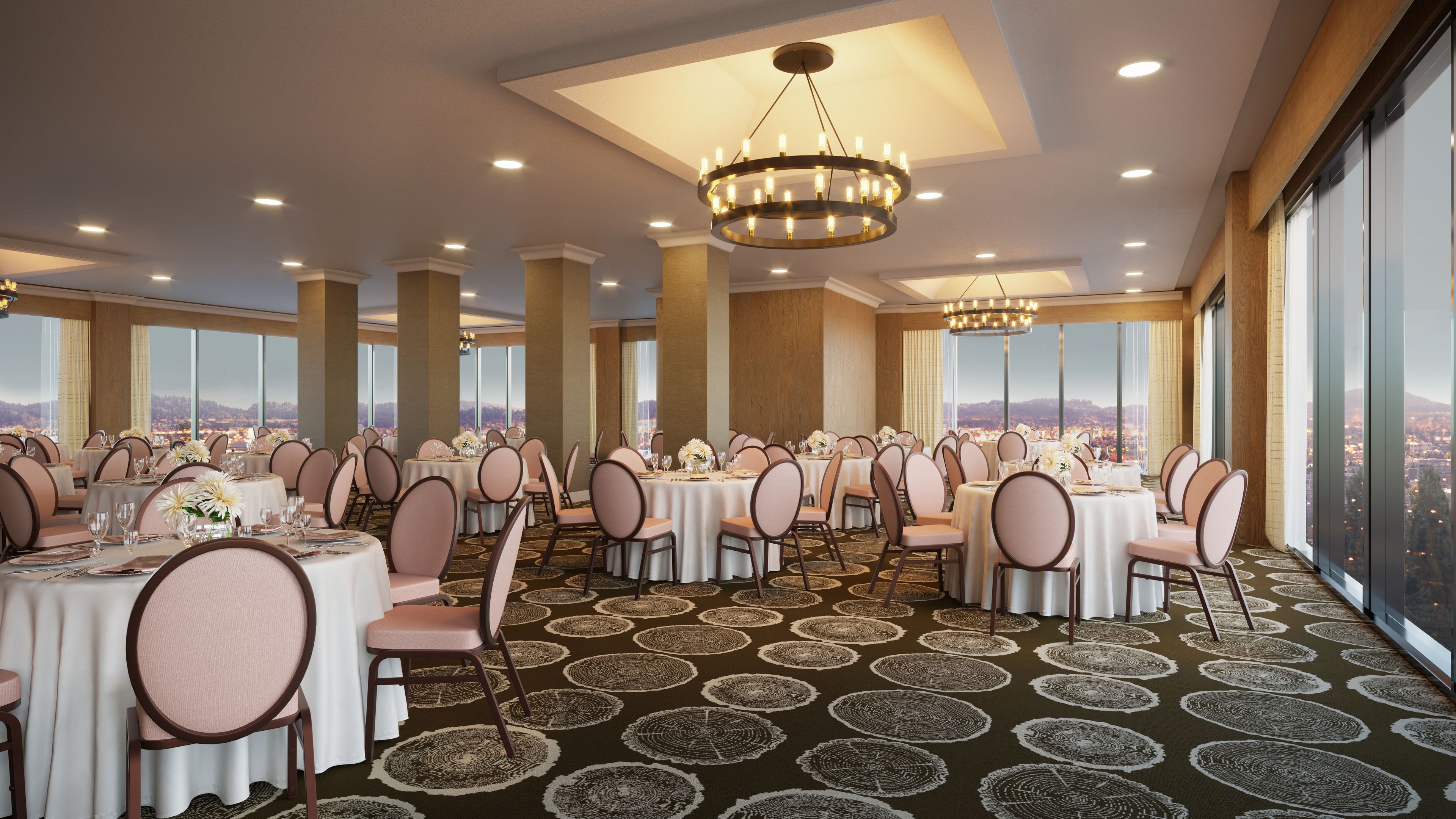 A banquet hall with round tables, chairs, and a chandelier.
