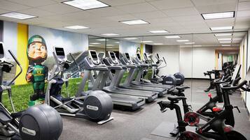 A gym with multiple treadmills, elliptical machines, and stationary bikes.