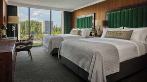 A hotel room with two beds, a desk, and a view of the city. - Graduate by Hilton Eugene (Eugene)