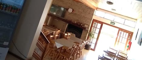Un restaurante con techo alto, escalera de madera y vista al salón comedor.