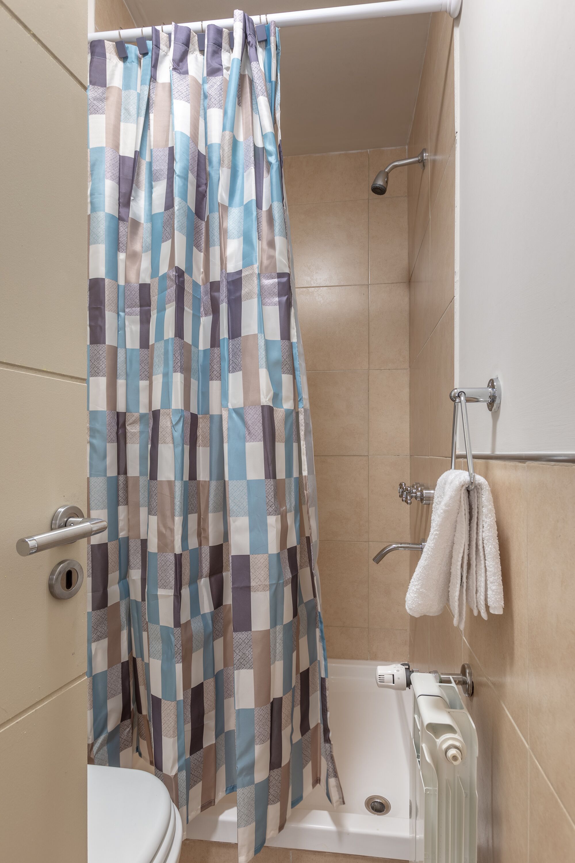A bathroom with a shower curtain, a bathtub, and a toilet.