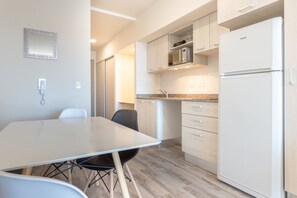 Estudio, vista a la ciudad | Cocina privada | Refrigerador, microondas, parrilla de estufa y utensilios de cocina 