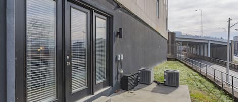 Un bâtiment moderne doté de grandes fenêtres, d’un chemin en béton et de groupes de climatisation installés à l’extérieur.