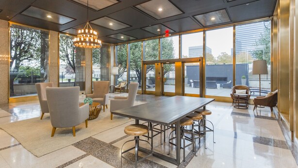 A spacious lobby with a large table and chairs, a chandelier, and large windows offering a view of the outside. - The Nashville Reserve (Nashville)