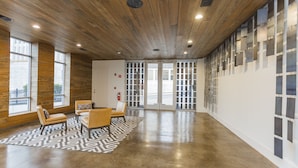 A spacious lobby with a high ceiling, large windows, and a seating area with chairs and a table. - The Nashville Reserve (Nashville)