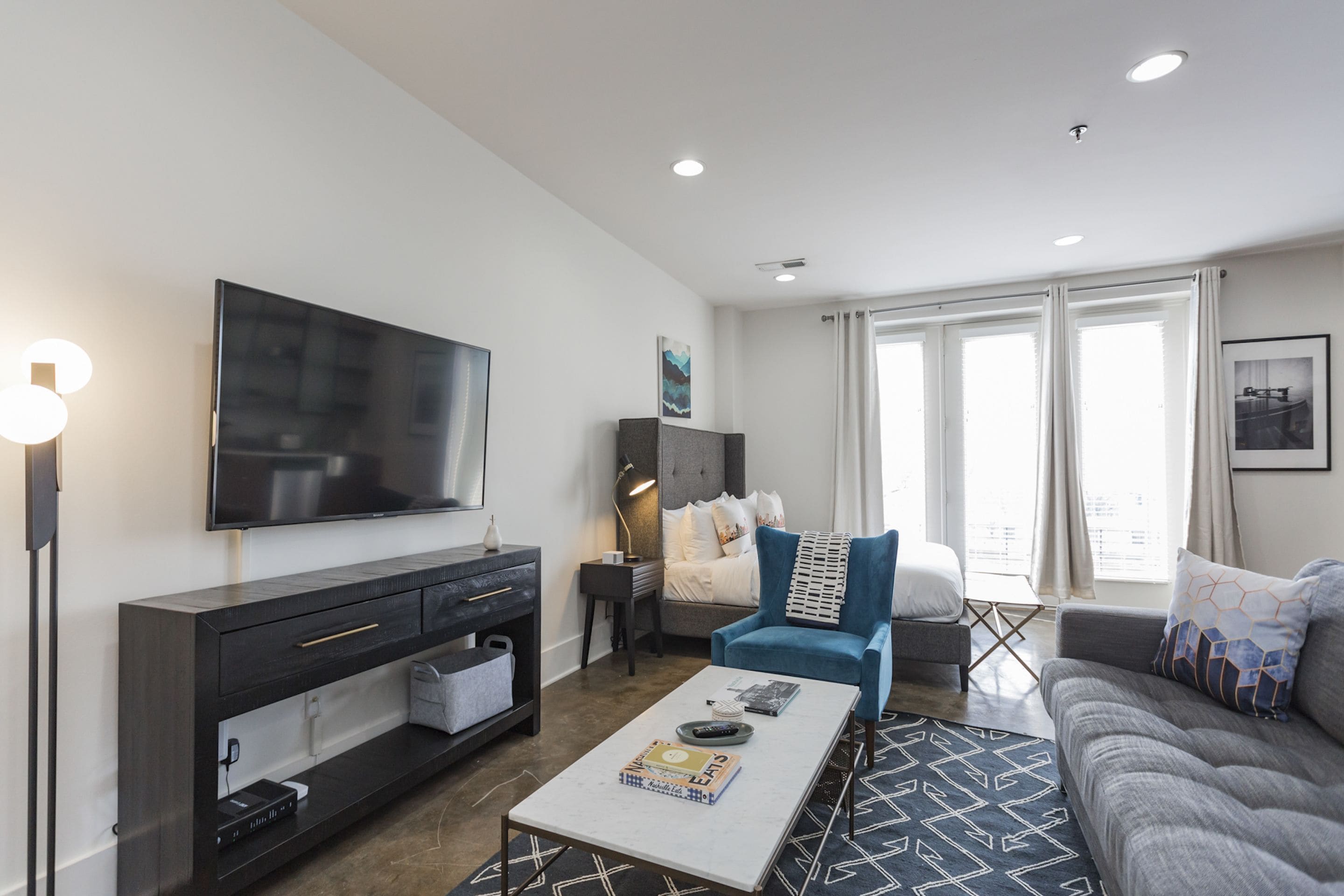 A modern living room with a flat-screen TV, a sofa, a coffee table, and a TV stand.