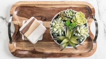 A wooden tray with a small white container and a potted succulent plant.
