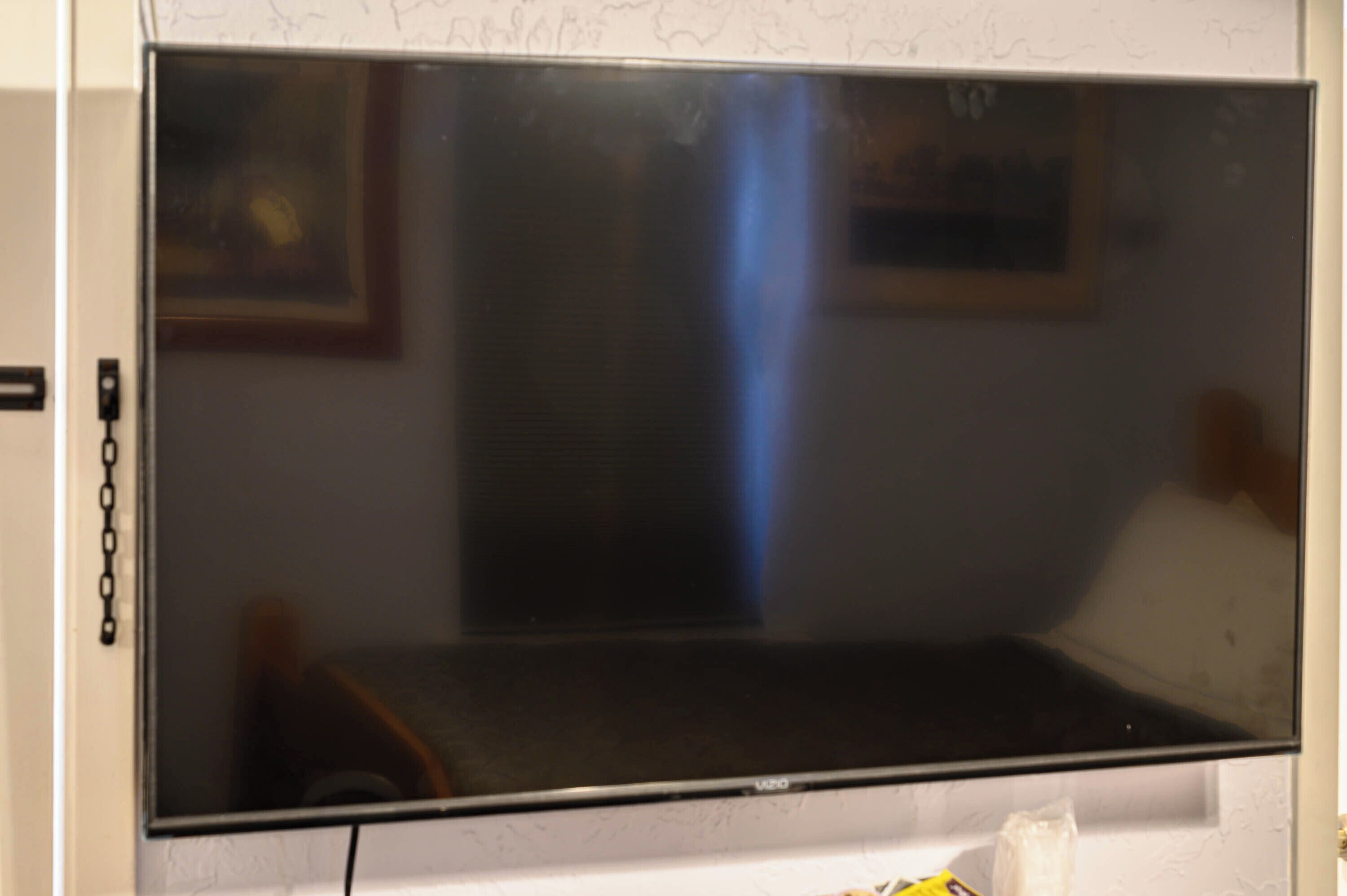 Une pièce avec une grande fenêtre, un lit et une petite table.