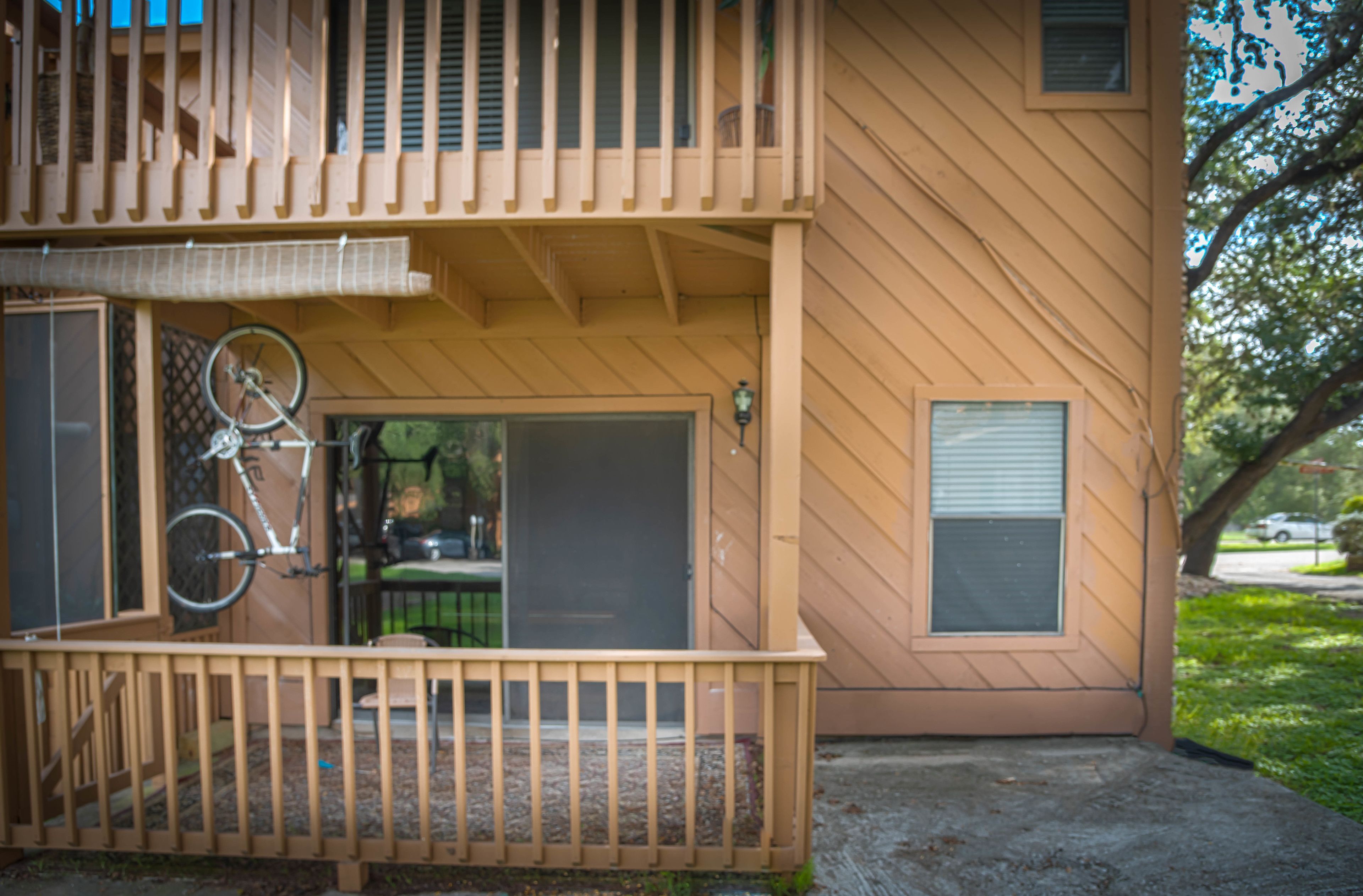 A two-story building with a balcony and a bicycle parked outside.