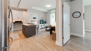 A modern kitchen with a refrigerator, microwave, and dining area. - Heaven in Charlotte Furnished Apartments (Charlotte)