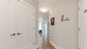 A hallway with white doors and a wooden floor. - Heaven in Charlotte Furnished Apartments (Charlotte)