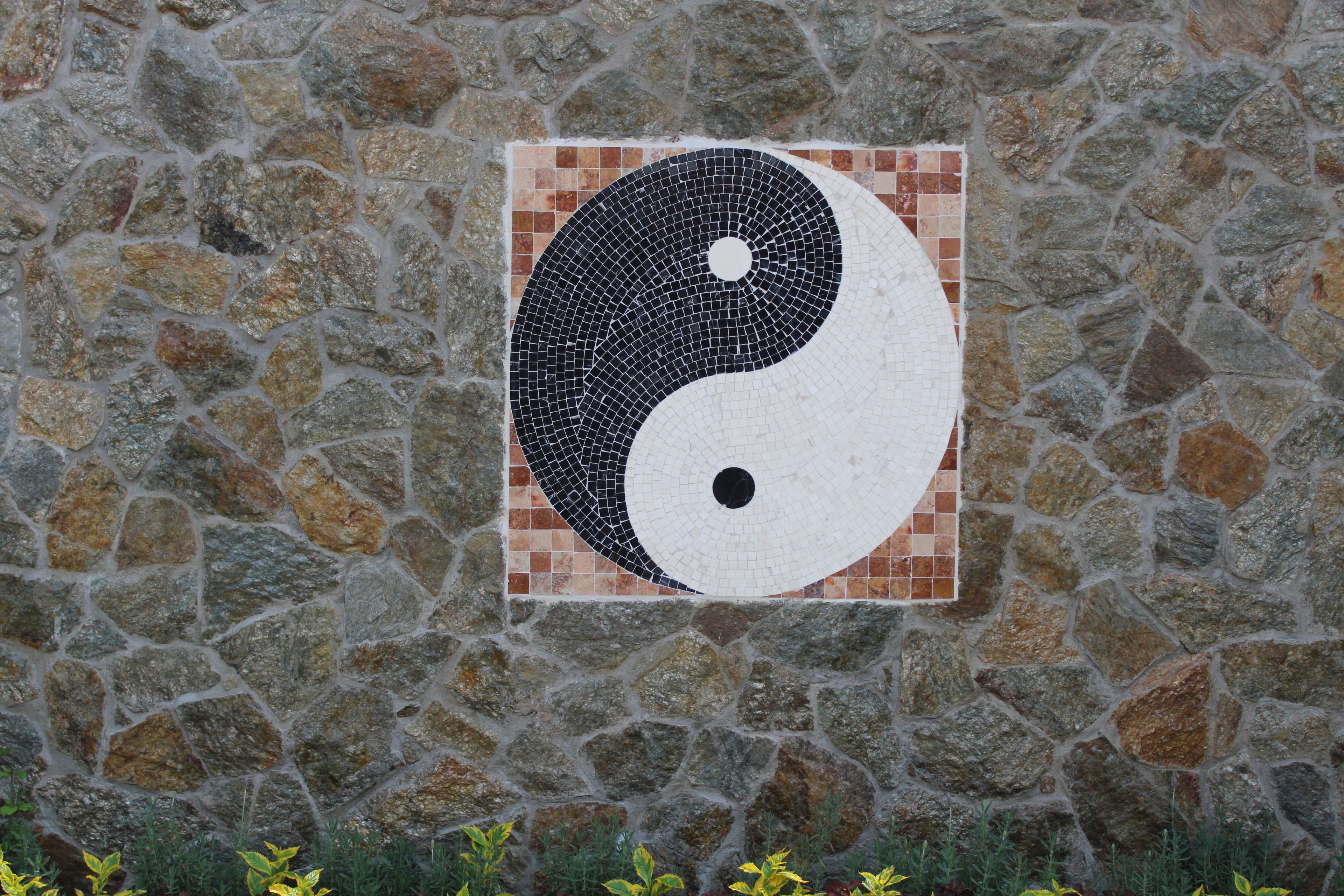 Um muro de pedra com mosaico do símbolo yin-yang.