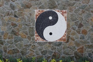 Um muro de pedra com mosaico do símbolo yin-yang.