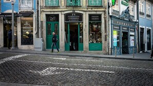 Un immeuble à plusieurs étages abritant une pharmacie au rez-de-chaussée, reconnaissable à sa porte verte et à son enseigne.