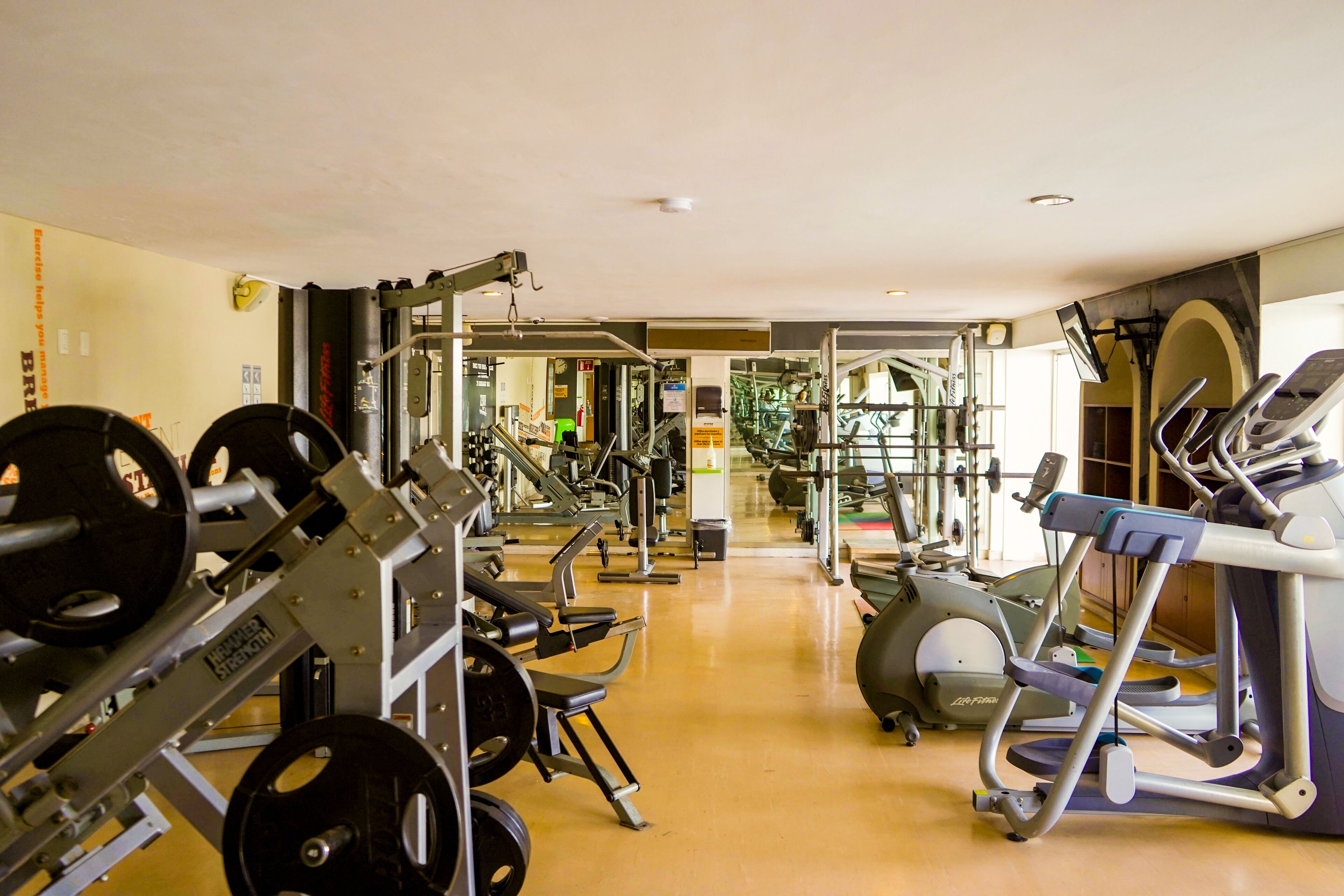 A gym with various exercise equipment, including weight machines and treadmills.