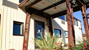 A building with a corrugated metal exterior, a wooden porch, and a window with the text "Iron Springs." - Iron Springs Adventure Resort & RV Park (Cedar City)