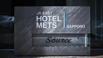 Een modern hotelschiltje met daarop 'JR-EAST HOTEL METS SAPPORO' en 'Source'.