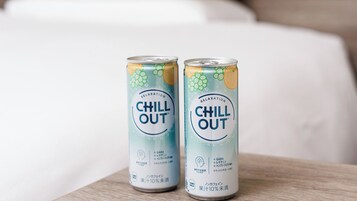 Two cans of 'CHILL OUT' beverage on a wooden surface.